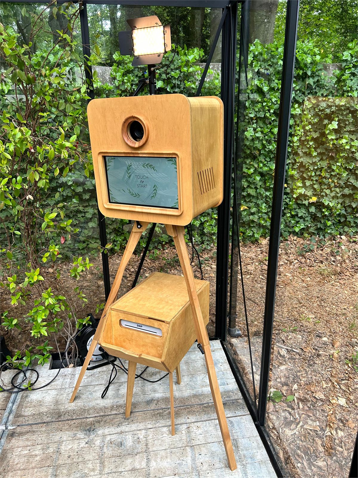 Houten photobooth op een driepoot, schuin van voren